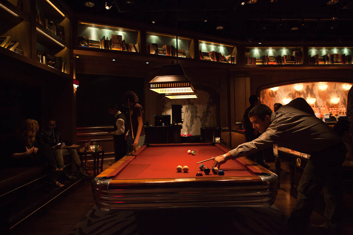 a man playing pool in a bar with a bill table