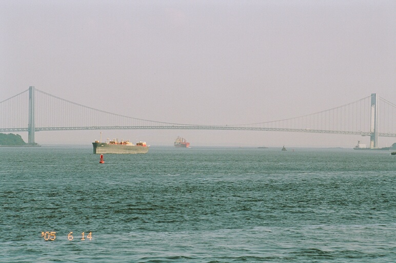 the ferry boat sails under the bridge on the ocean