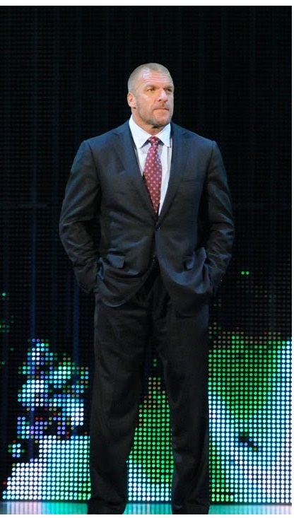 a man in suit and tie standing on stage