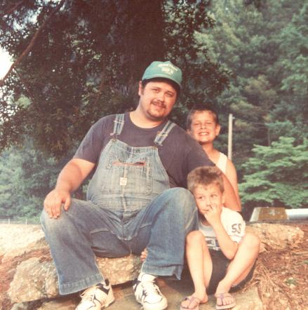 two children and an adult sitting on rocks