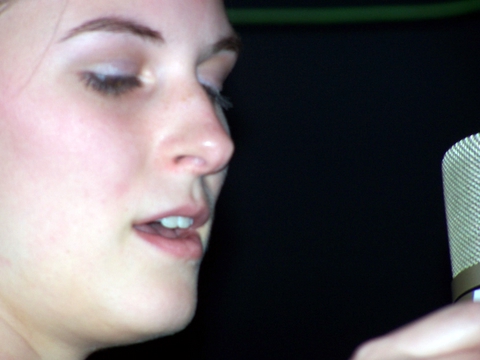 a woman with a microphone up close to her face