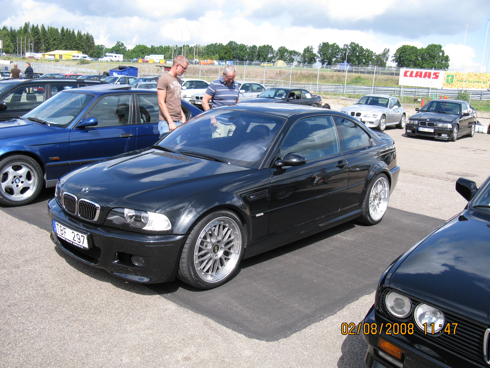 a black car with chrome wheels parked in a lot