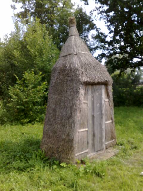 a garden outhouse sitting in a lush green field