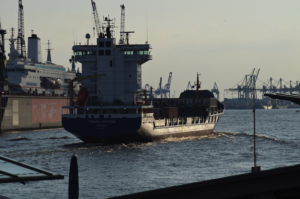 a ship sailing down a river next to a dock