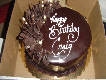 the birthday cake is made of chocolate frosting and decorated with decorative flowers