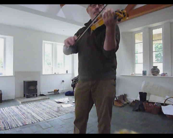 a man in a living room with a violin