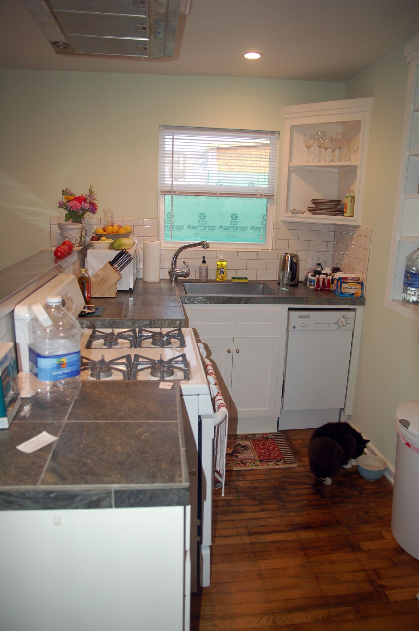 a kitchen area with stove, sink and window