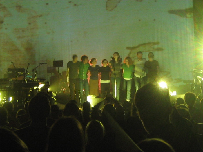 a group of people standing on top of a stage next to each other
