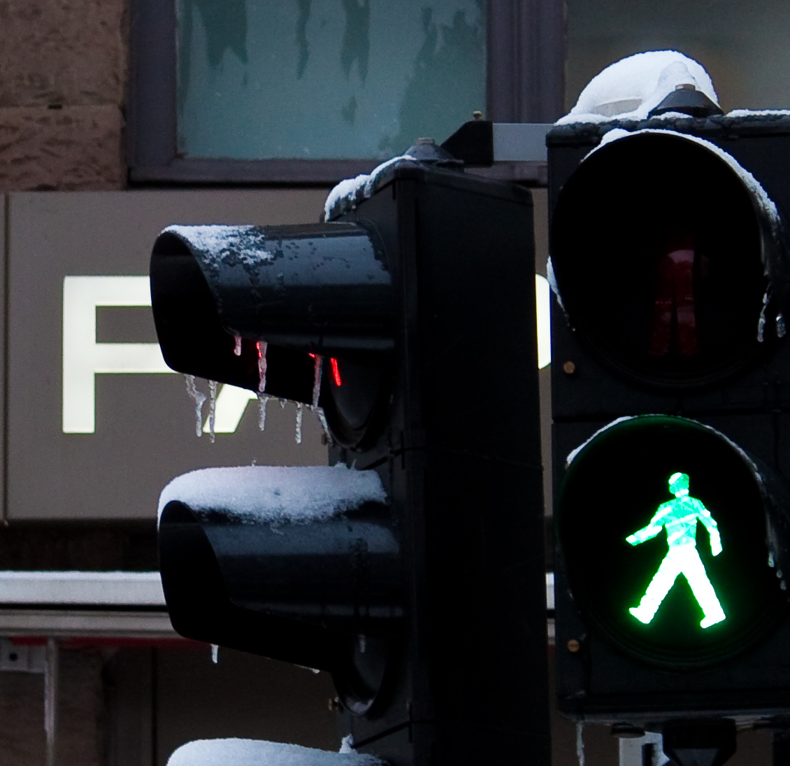 a green traffic light with a person walking on it