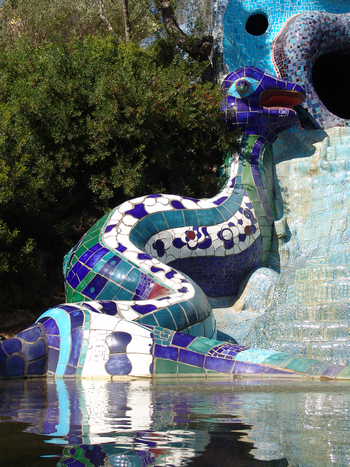 a dragon sculpture in a lake on top of the rock