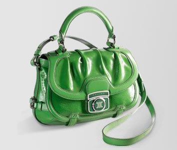 a green handbag, with an attached strap, on a white background