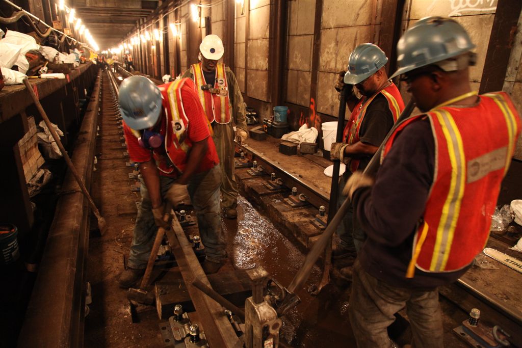 some construction workers in hard hats and orange vests