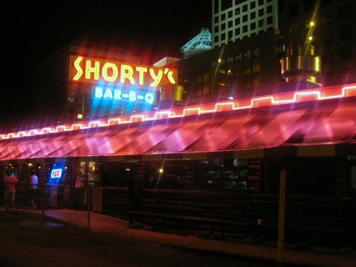 a brightly lit neon sign for shorty's bar - b - q