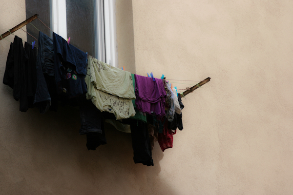 clothes on a line outside of a house hanging outside