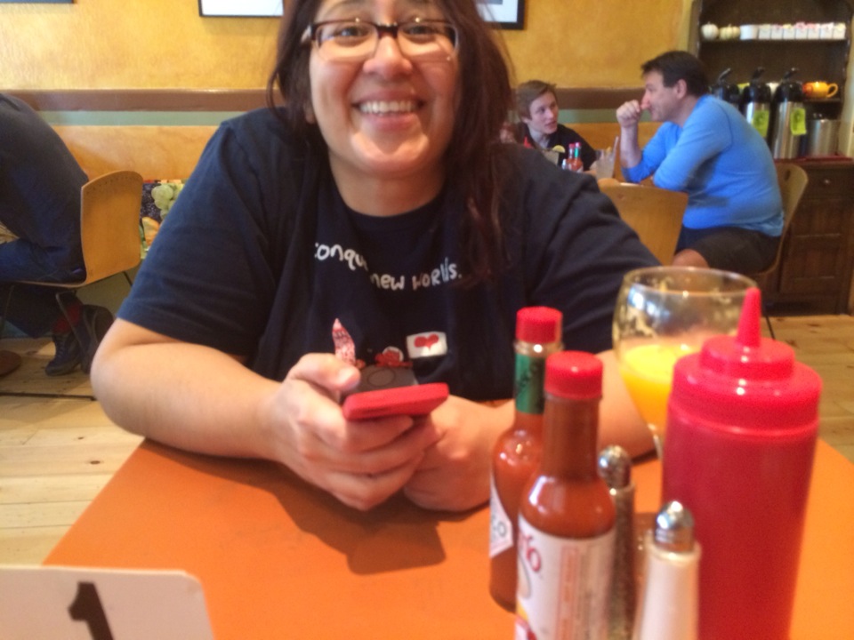 a woman sitting at a table using her phone