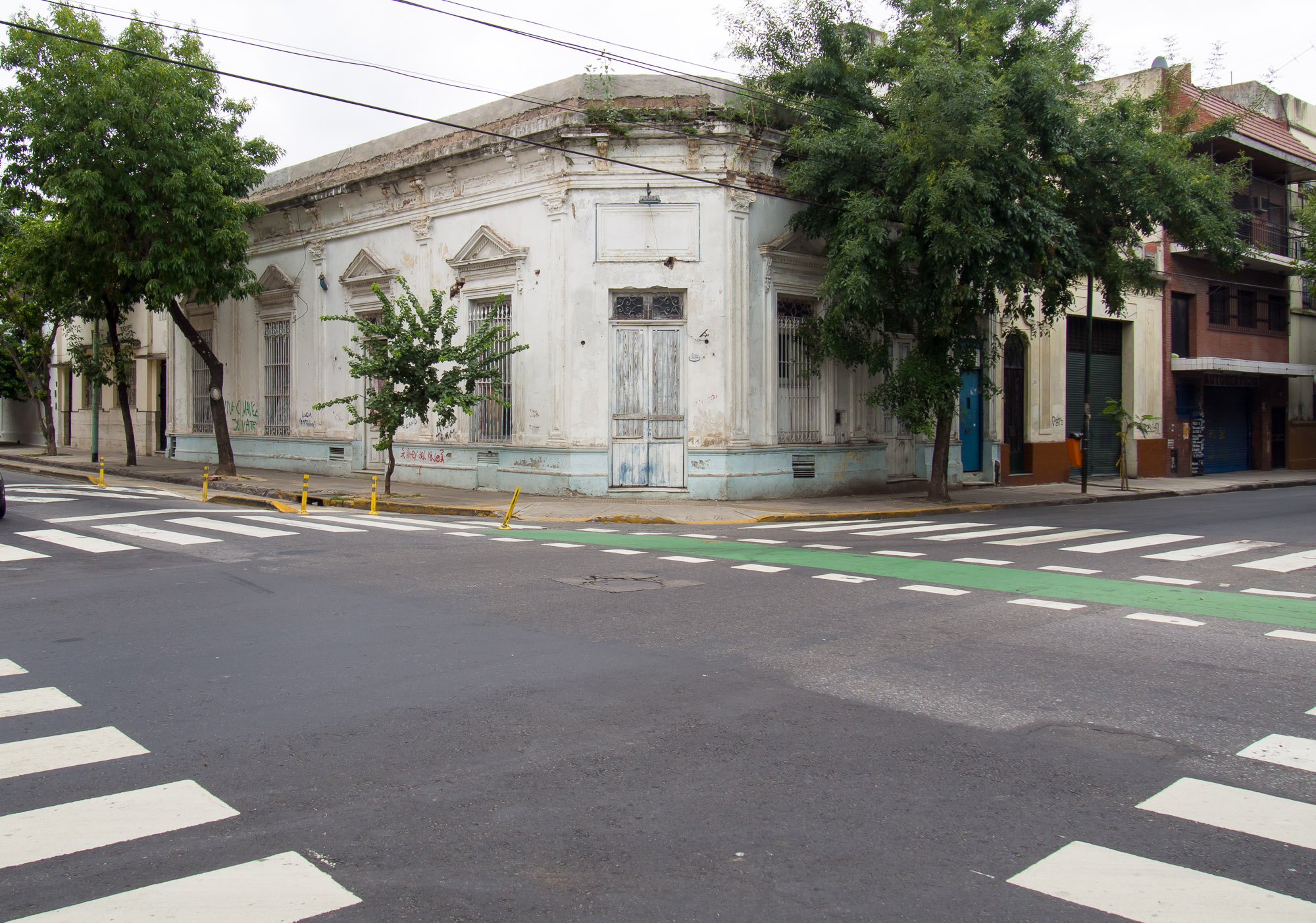 an intersection with crosswalk and a white building