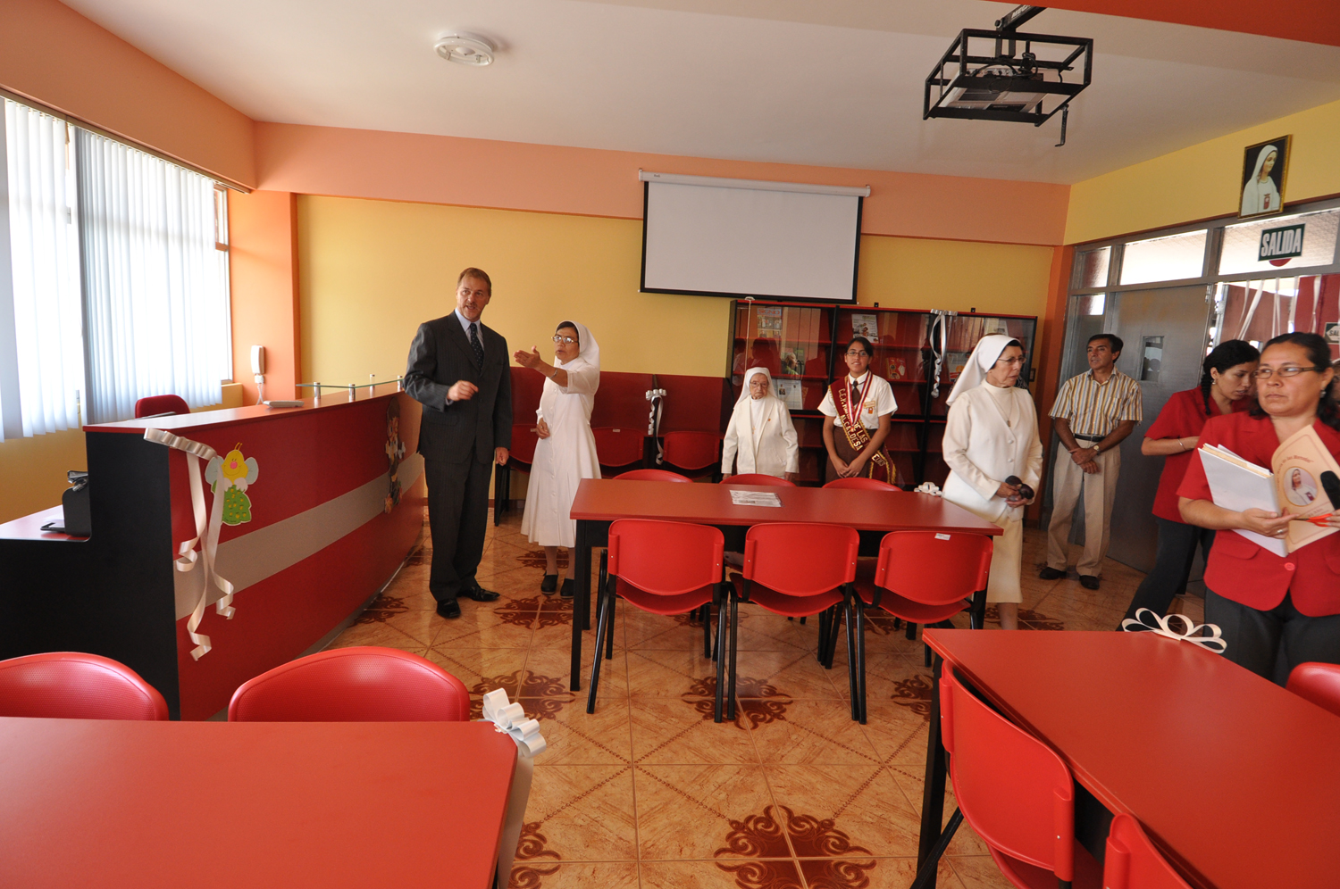 people standing around a large red table filled with people