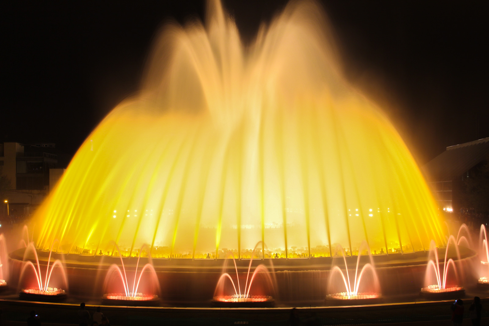 brightly lit water fountain at night near lights