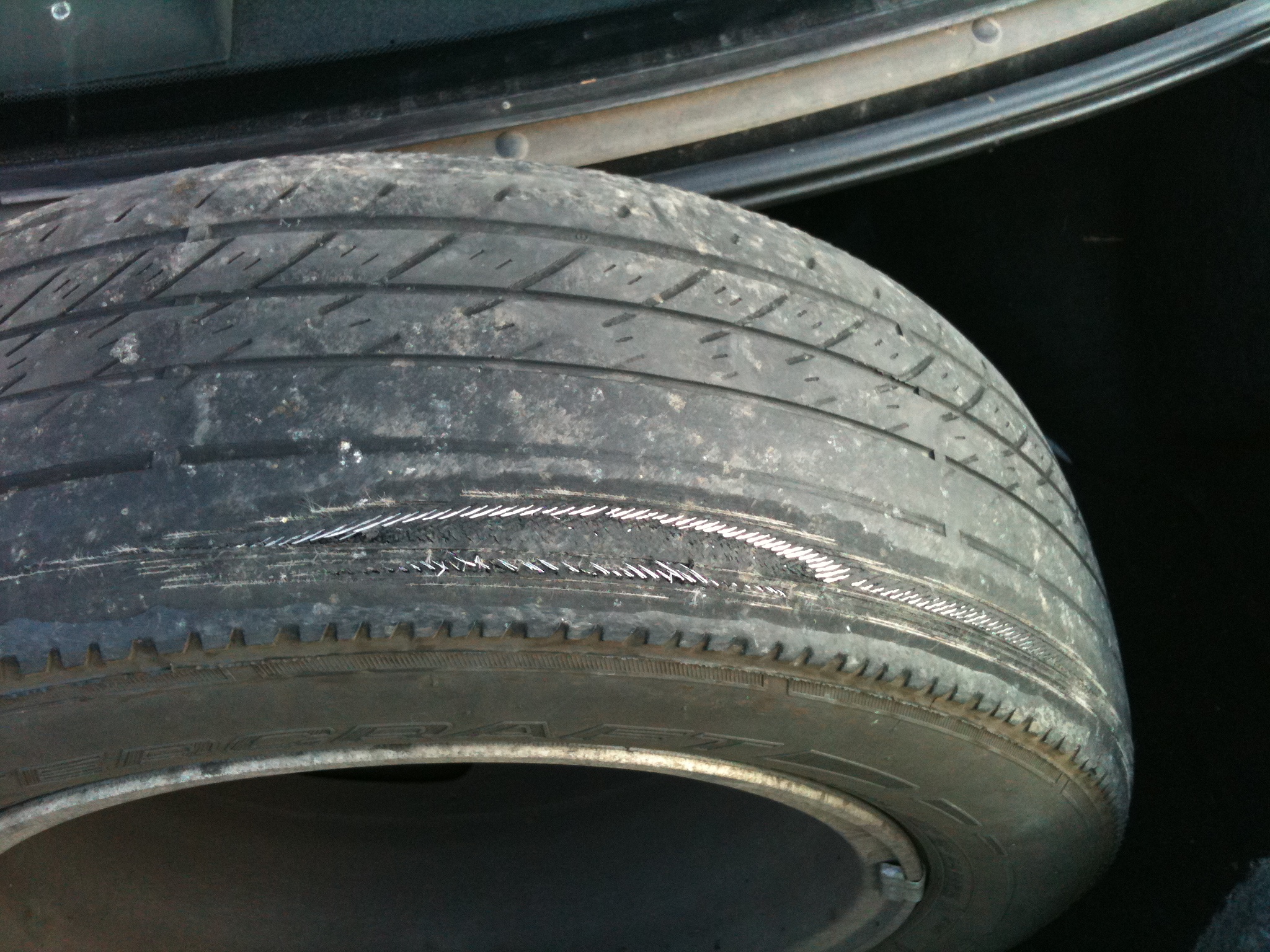 an old, worn down tire on the side of a car