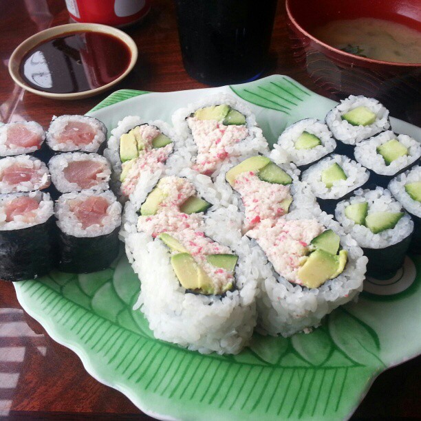 some sushi on a green plate near other food
