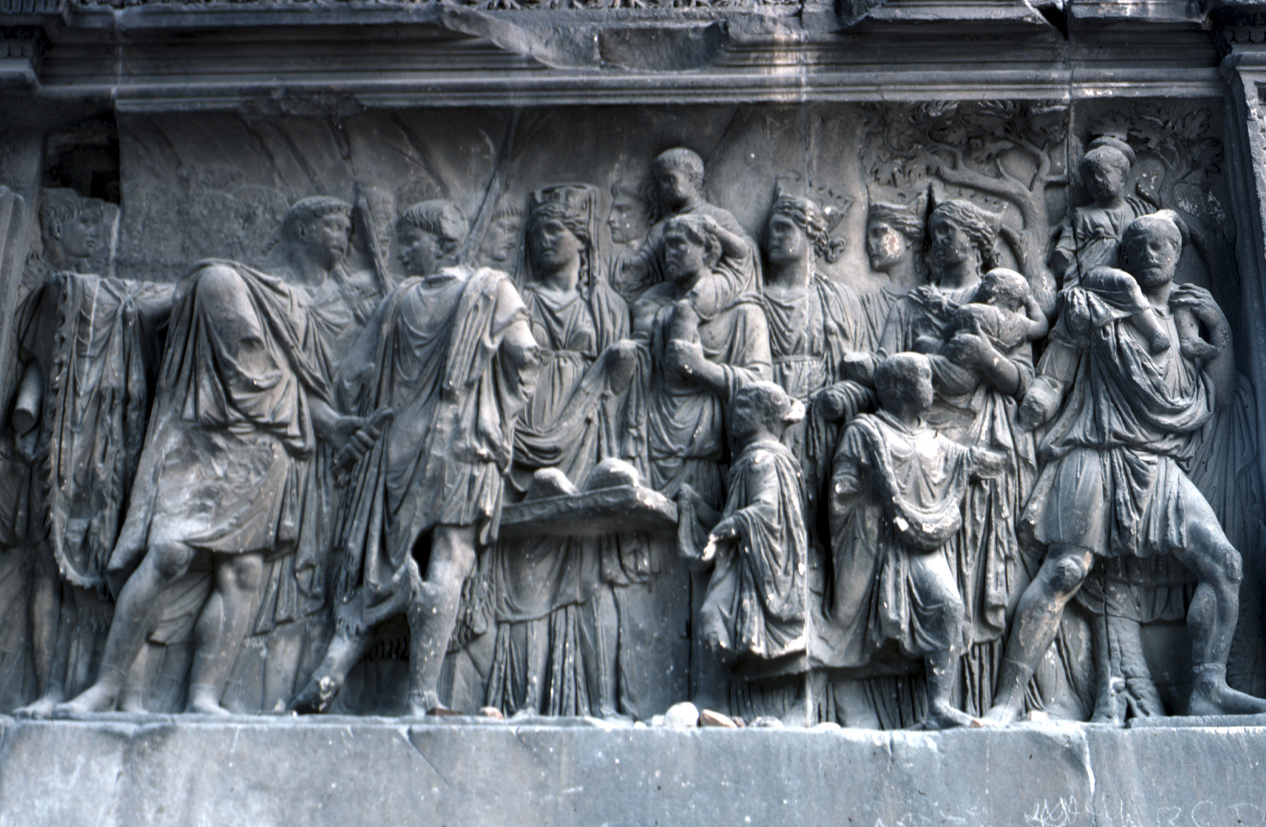 carvings on the wall of a building with people standing around