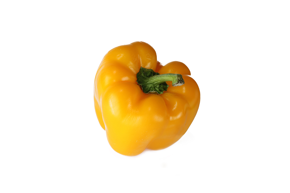 yellow pepper with green leaf on white background