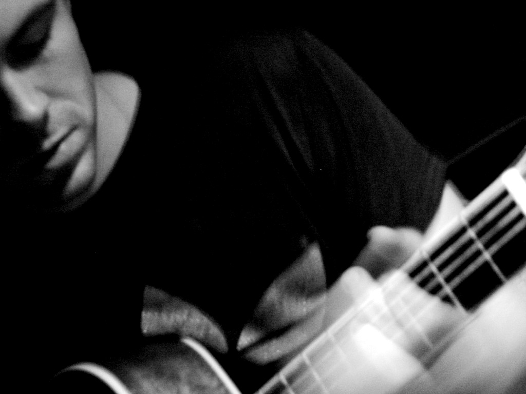black and white pograph of man playing guitar