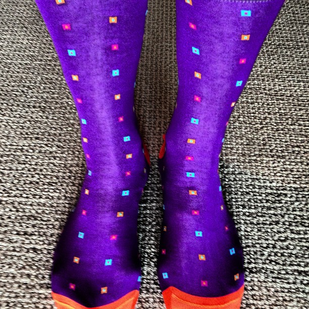 a purple woman's legs with colorful socks on