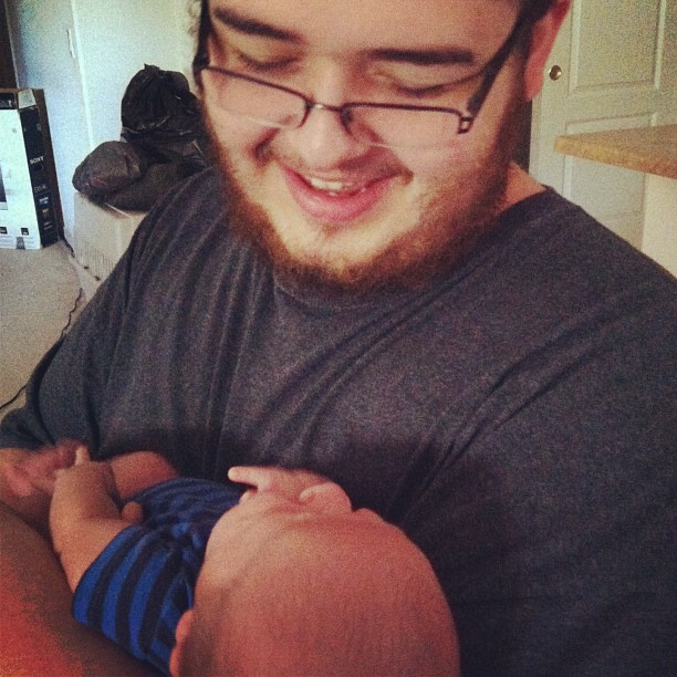 a baby smiles and hugs his dad