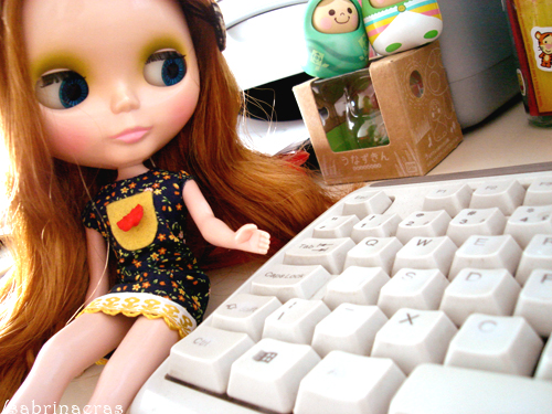 a close up of a doll on a desk with a keyboard