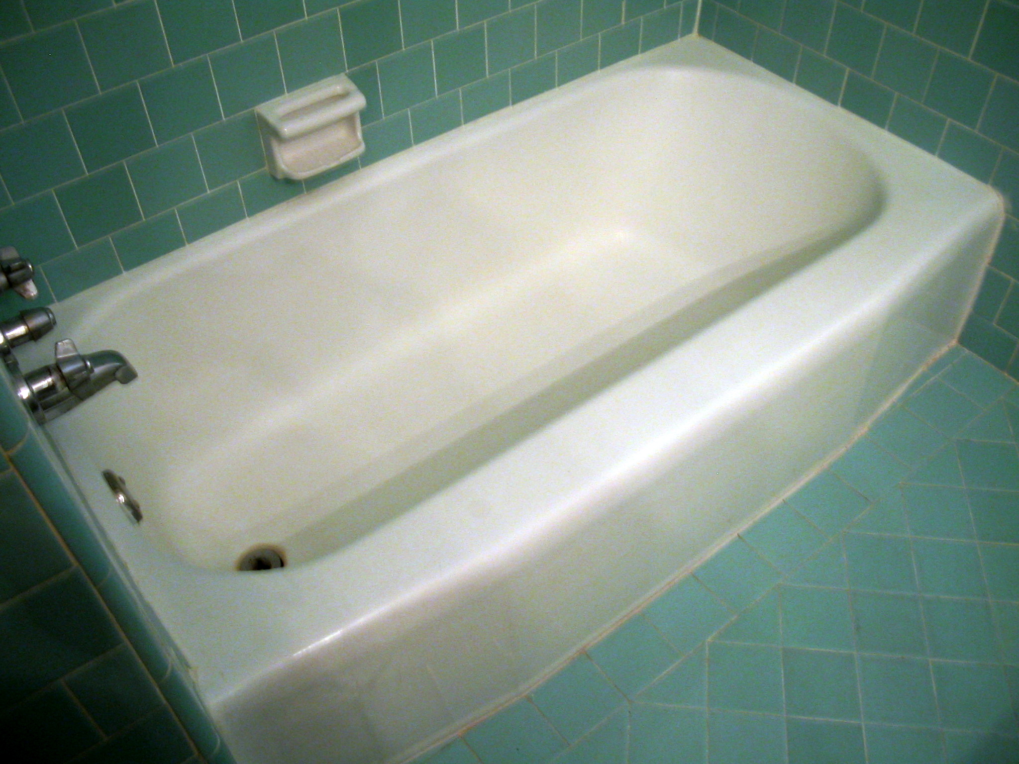 a white bath tub sitting in a tiled bathroom