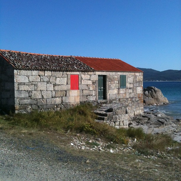 an old house on the shore with no roof