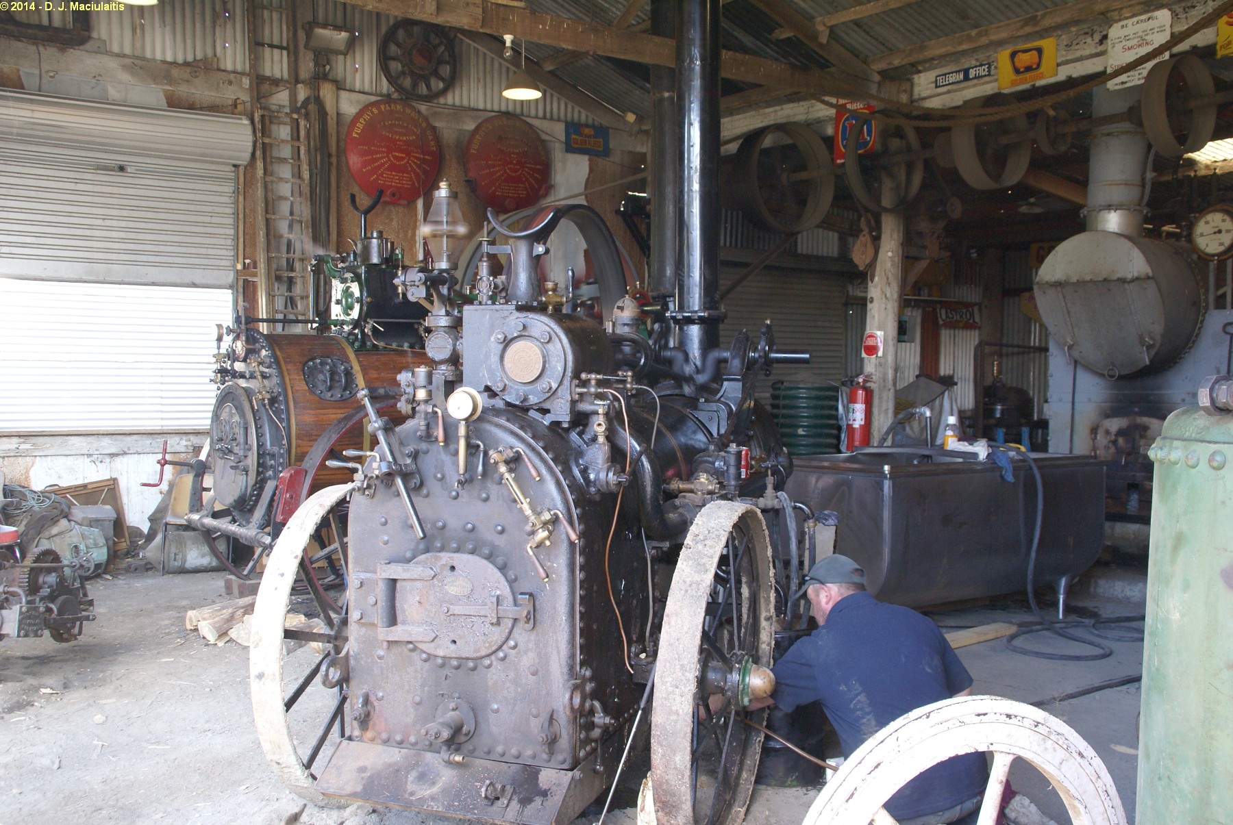 a man works on a large machine at a shop