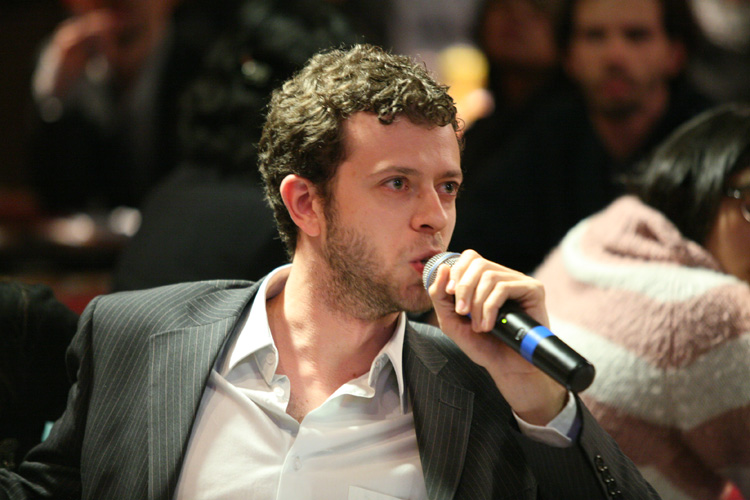 man sitting on chairs with microphone in front of people
