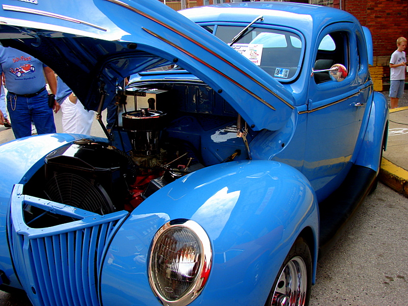 a classic blue car with its hood up