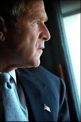 a man wearing a suit and tie looks out a window