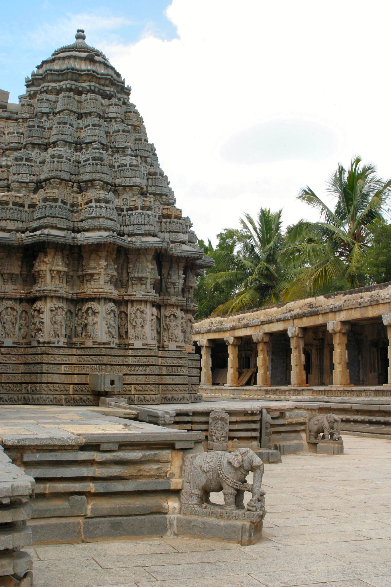 an elephant statue is placed in a courtyard near a stone temple