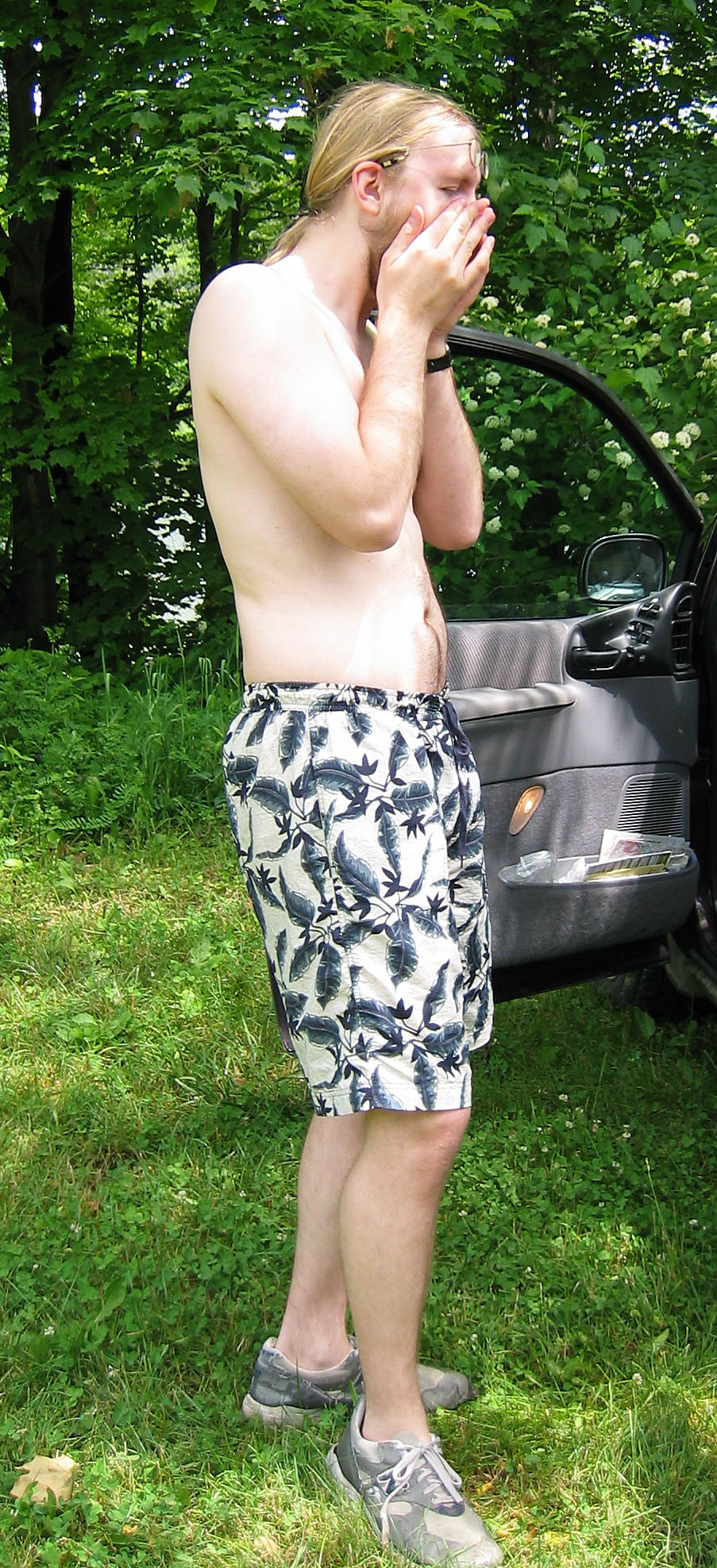 a shirtless man standing in front of a black truck
