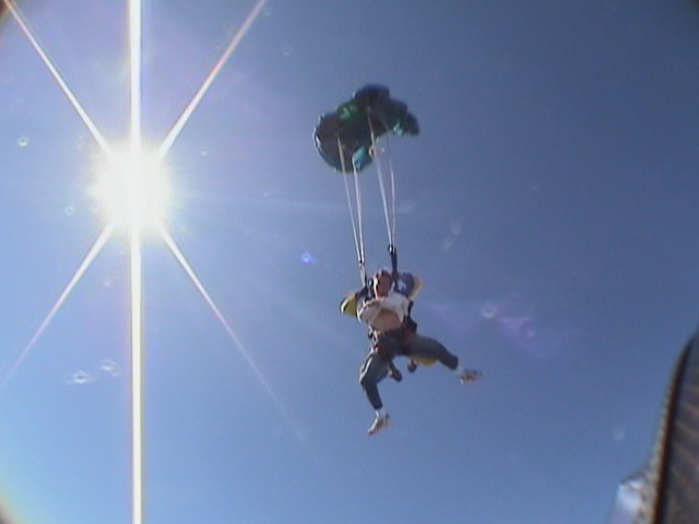 a parasailer in mid - air with his parachute being attached