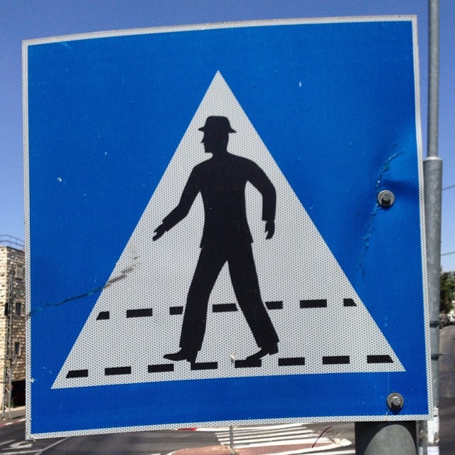 a man is walking through the intersection sign