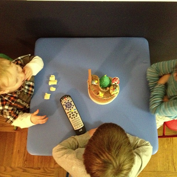 two children playing with a table and tv remote control