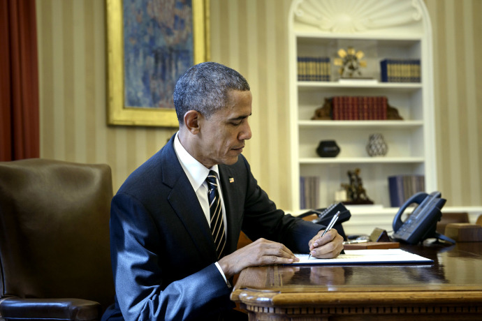 the president is writing in his white house executive desk
