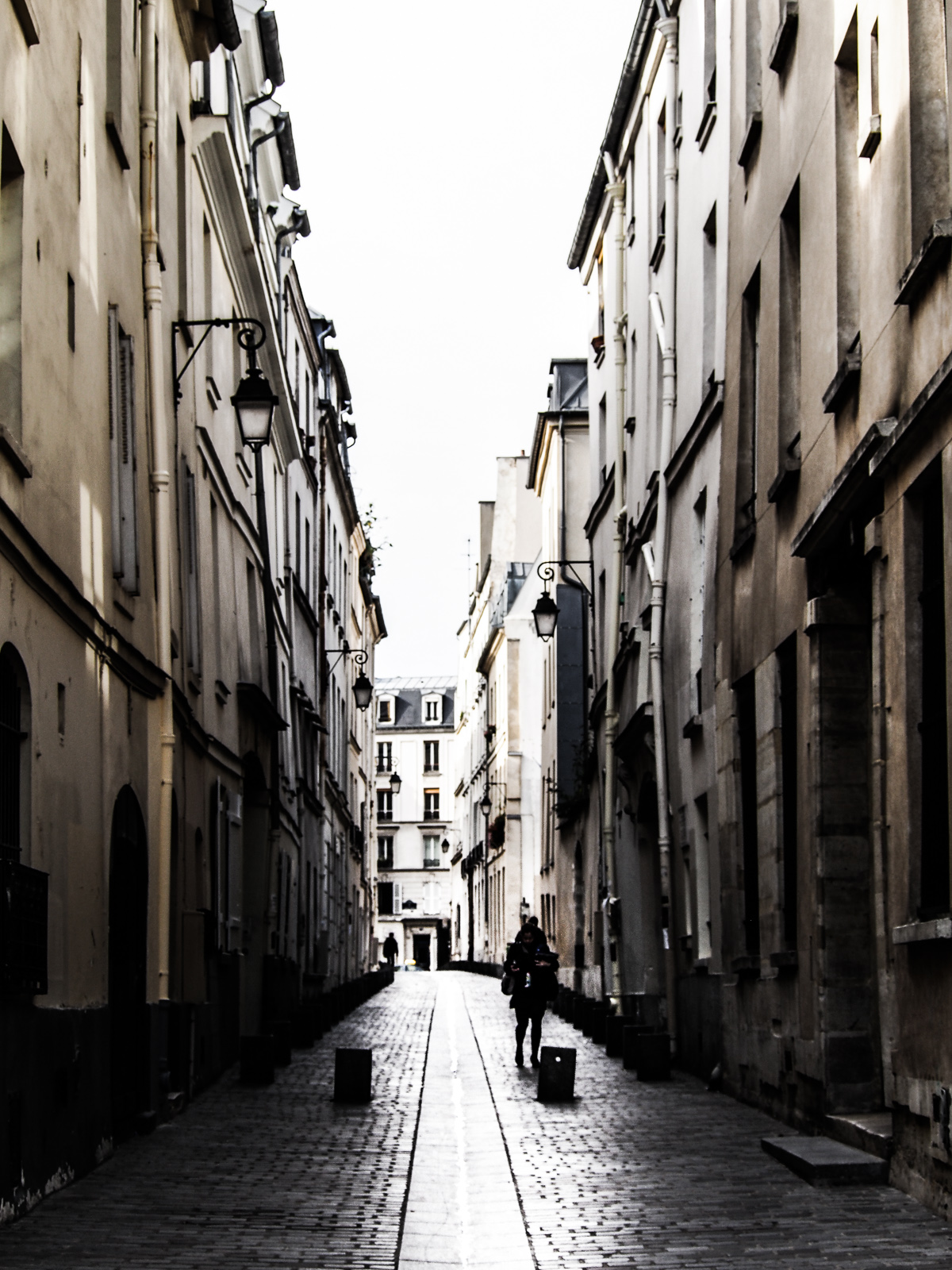 a stone street in the middle of two buildings