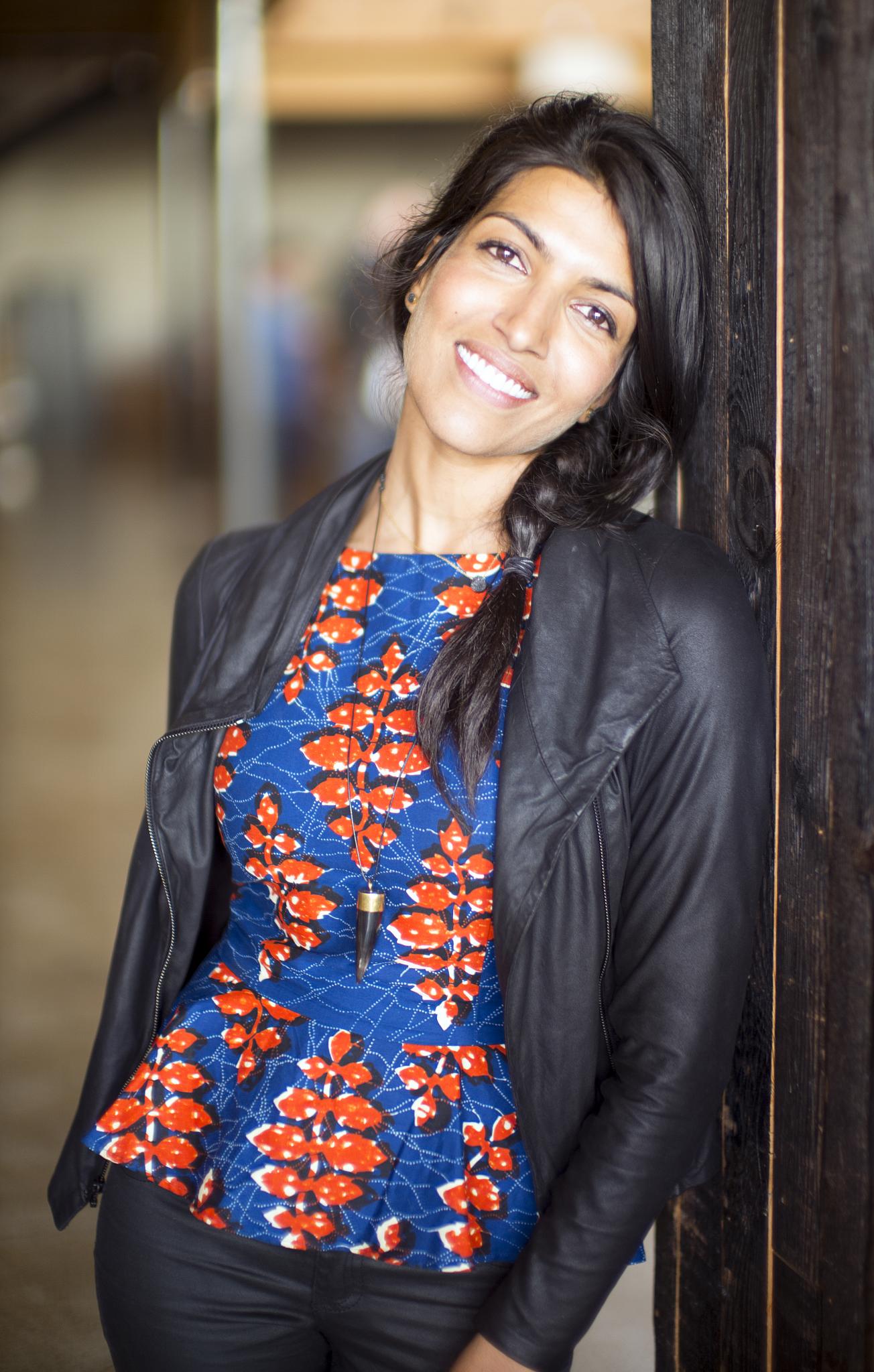 an attractive lady with a smile standing by some doors