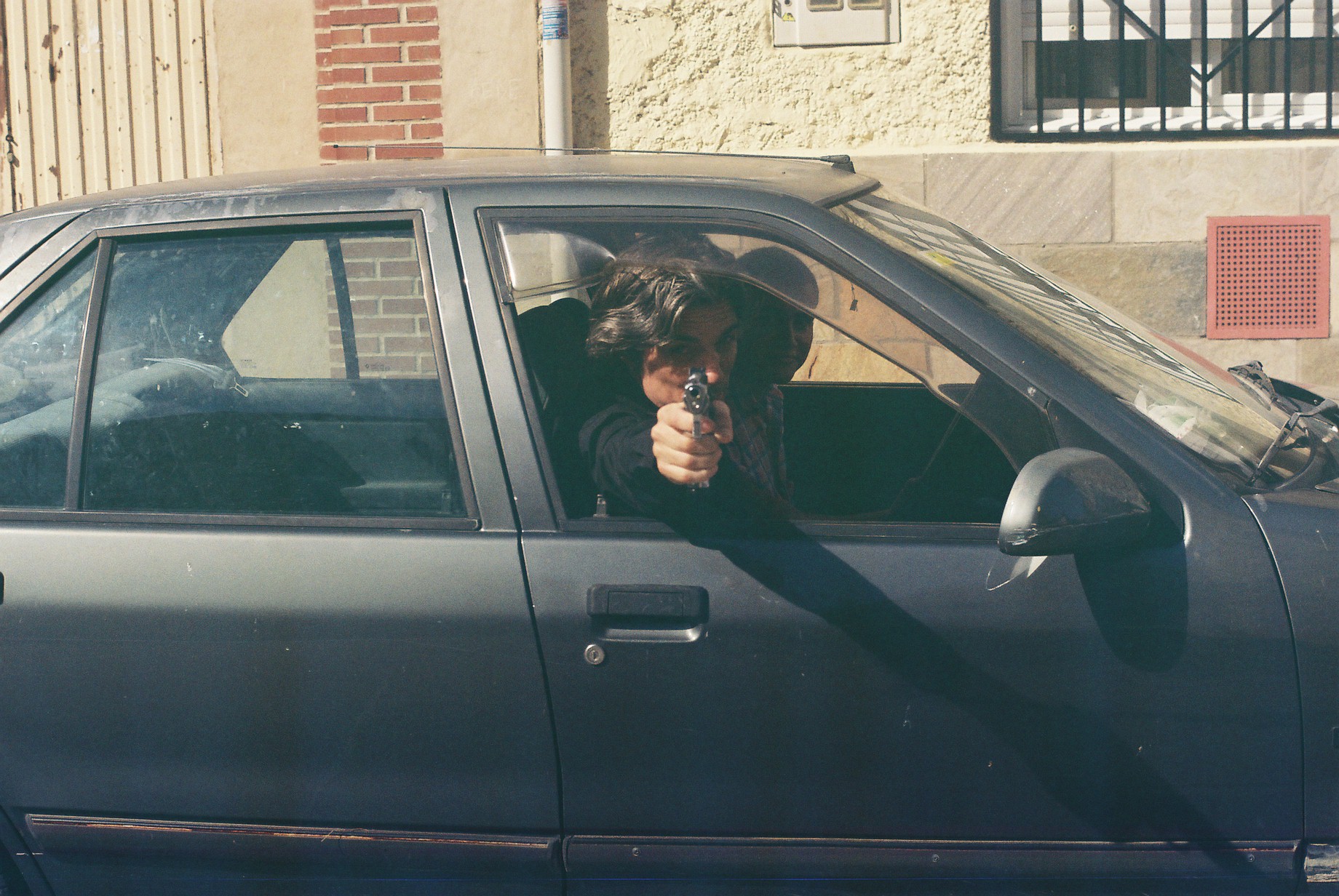 a woman is holding her gun in the back window of her car