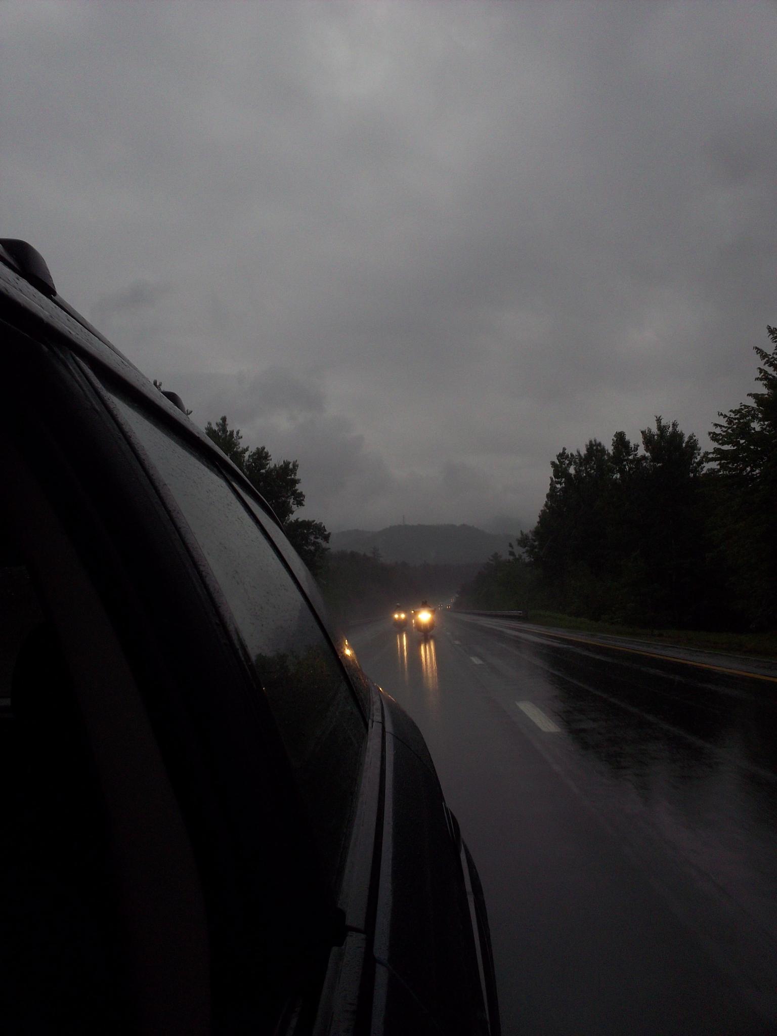 the headlights on two cars at night, with one coming off and another going down the road