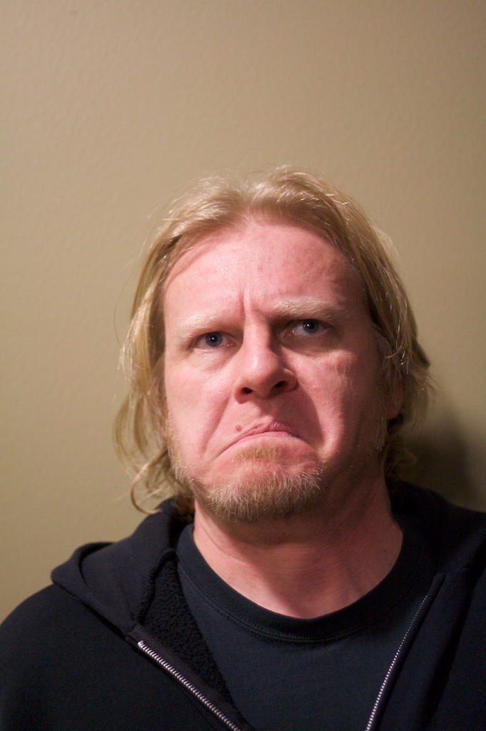 man with blue eyes and blond hair staring directly into the camera