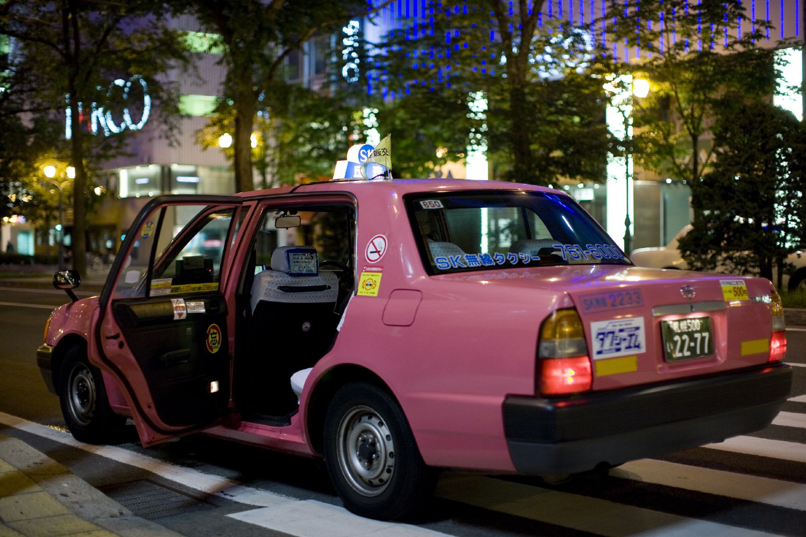 the small car has been painted pink to brighten up the city night