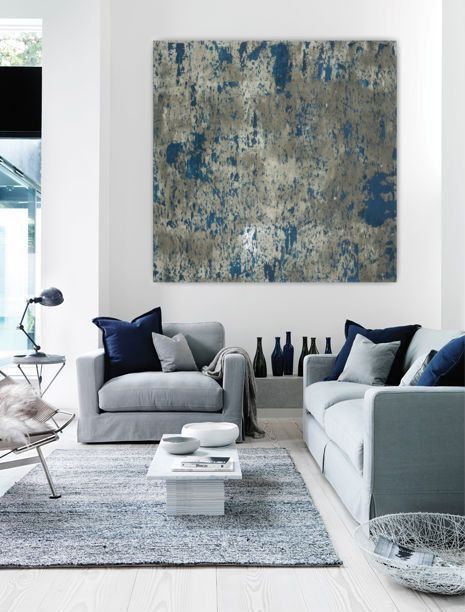 a modern living room decorated in a grey and blue hue with a touch of blue
