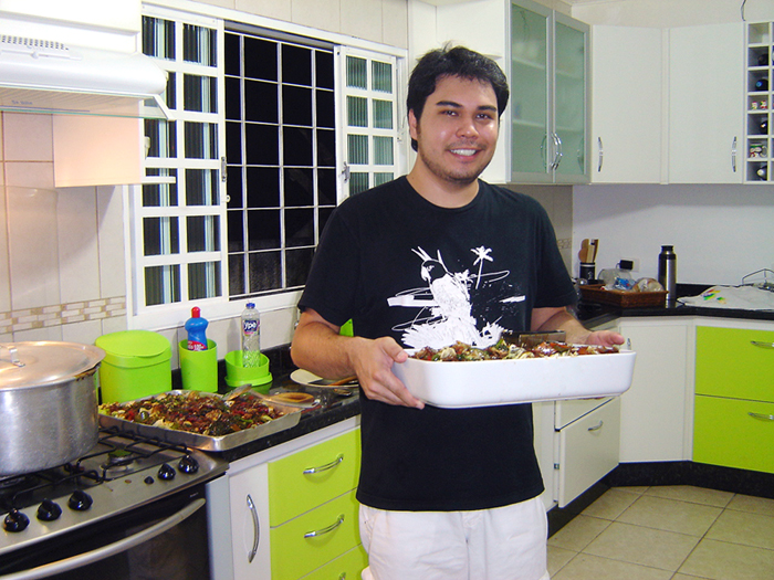 a man in his kitchen displaying some food